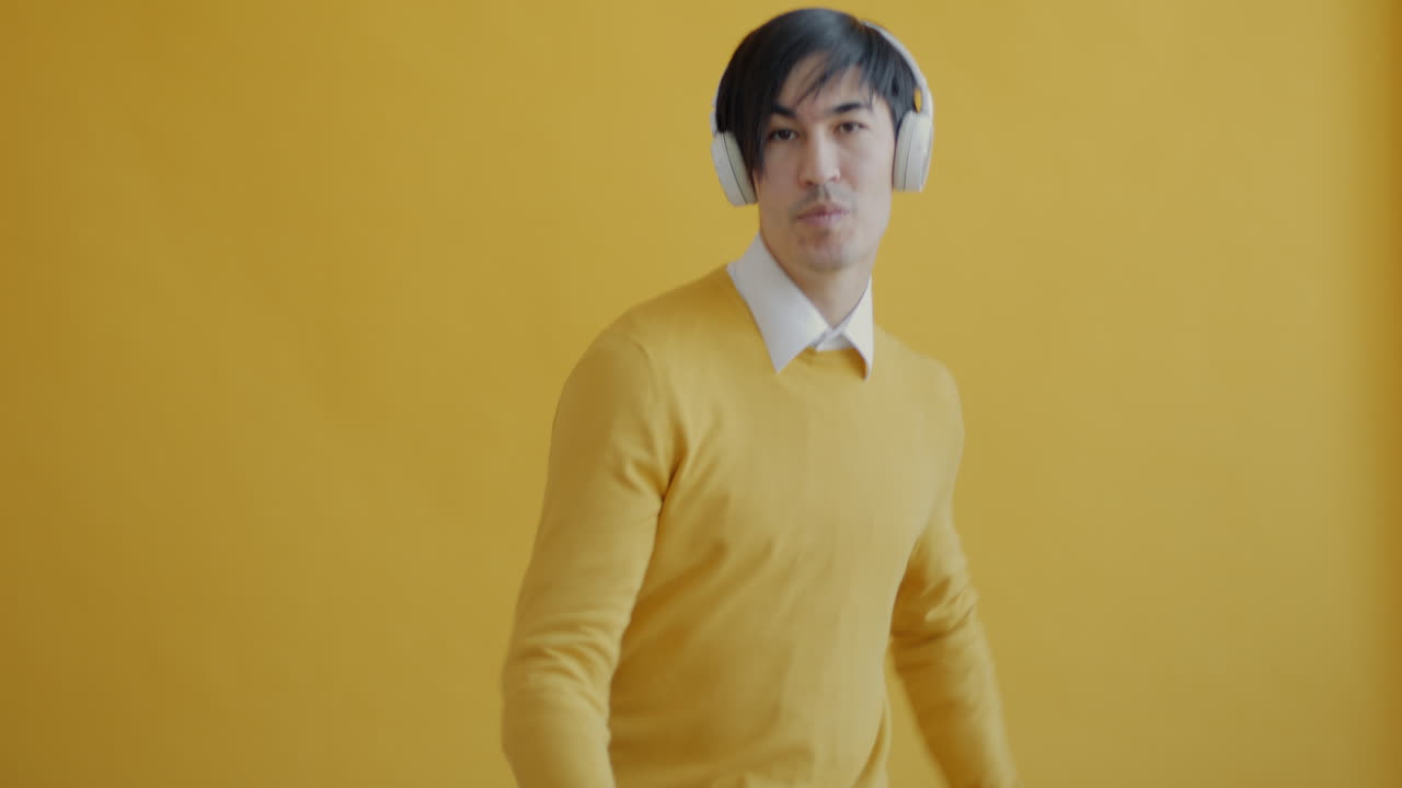 Man Dancing with Headphones on a Yellow Background
