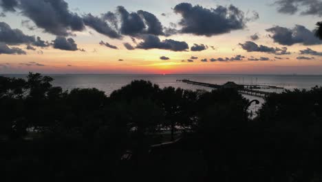 Aerial-view-of-sunset-over-Mobile-Bay,-Seahorse-sculpture-in-Alabama