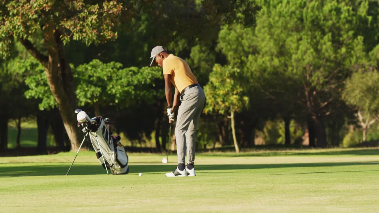 Video of african american man playing golf on golf field