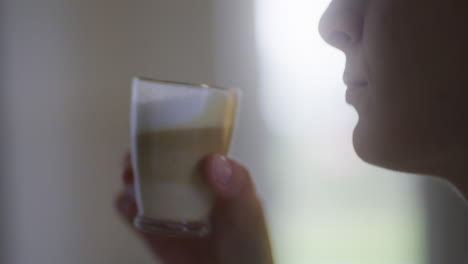 a woman drinks freshly brewed latte and enjoys it