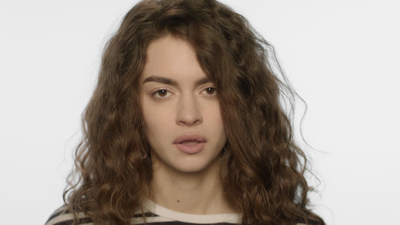 아픈 젊은 여성이 스튜디오에서 재채기를 하고 있습니다.