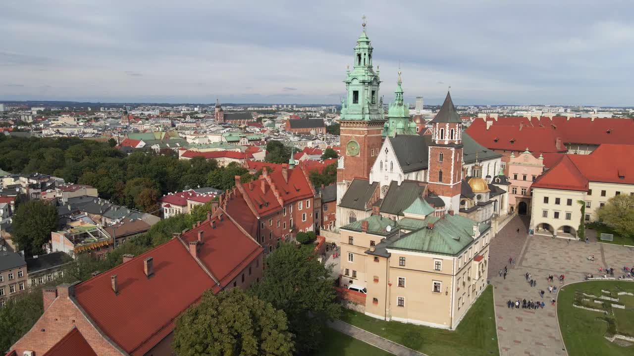 Aerial drone view of the Wawel Royal Castle, the cathedral and a courtyard with walking people in sunny day