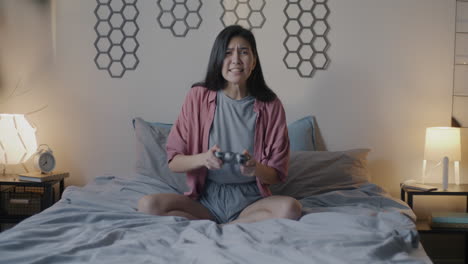 angry woman playing video games in bedroom