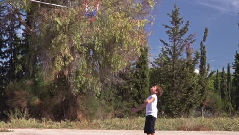 Niño-Caucásico,-Toma-Un-Tiro-Detrás-Del-Aro,-En-La-Cancha-De-Baloncesto-Del-Callejón,-Cámara-Lenta