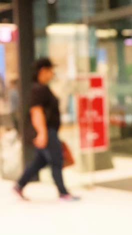 personas entrando y saliendo del centro comercial