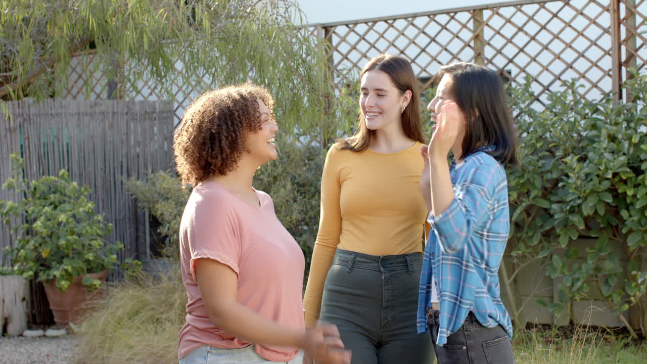 Talking and laughing, three women friends enjoying time outdoors together