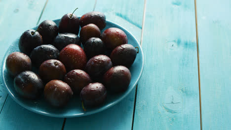 Plums-on-blue-plate-on-table