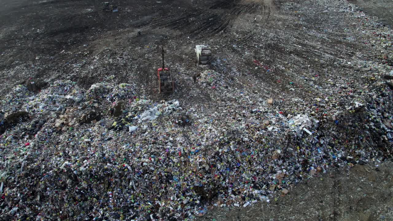 Landfill Site with Waste Piles and Garbage Trucks