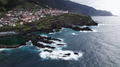 Felsige-Klippen-Und-Kleine-Stadt,-Madeira,-Portugal,-Drohnenantenne