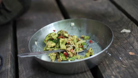 hombre vertiendo comida para acampar del paquete en un plato para acampar