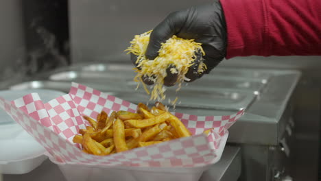 adding cheese and marinated meat while making carne asada smothered fries - food truck series