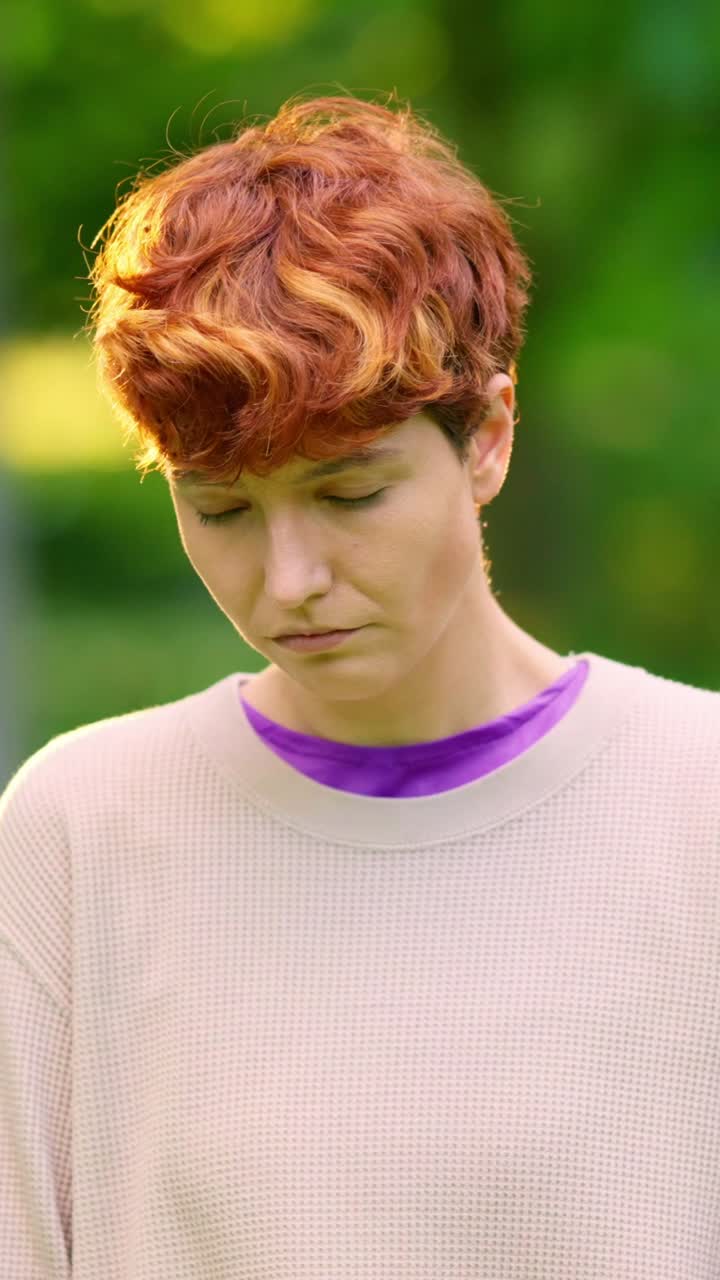 Portrait of a young woman with short red curly hair