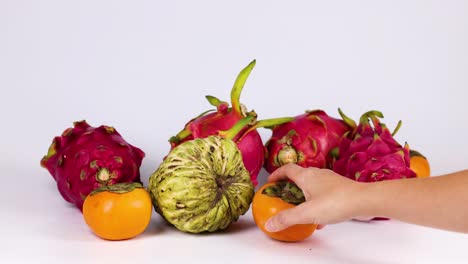 hands selecting fruits from a colorful arrangement