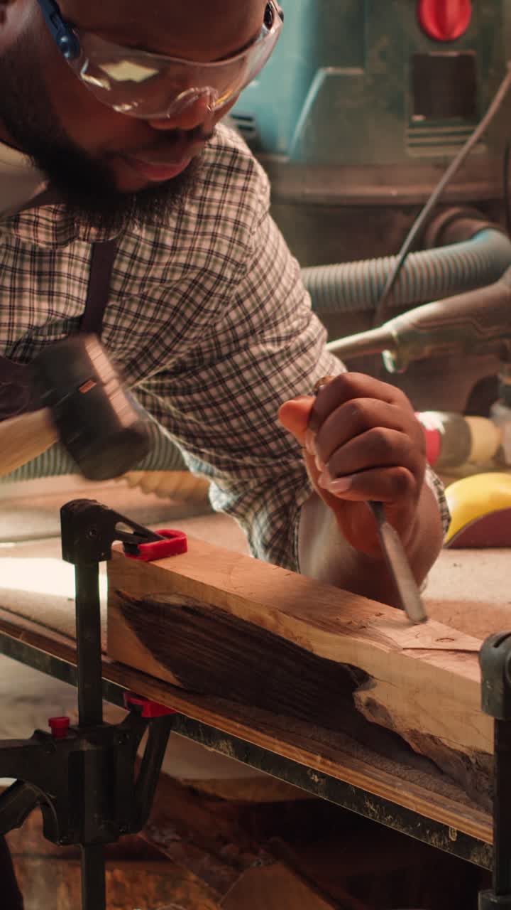 Man Carving Wood with Chisel and Mallet in Workshop