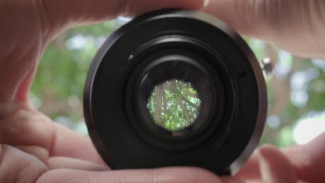 woman photographer checks aperture on camera lens