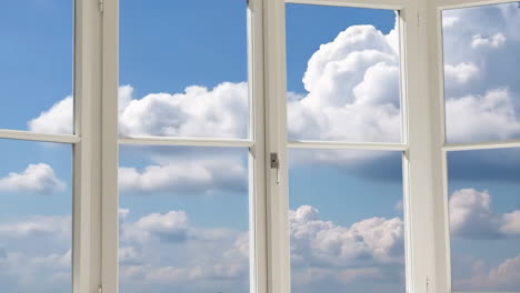 a clear blue sky with fluffy clouds through a window