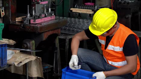 el trabajador de la fábrica está inspeccionando visualmente las piezas de trabajo (la placa de acero redonda).