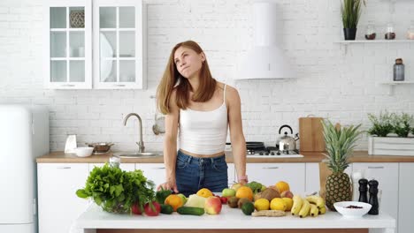 girl with a tablet chooses recipes. white kitchen and table with vegetables and fruits for a healthy diet