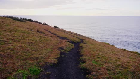 Blick-Auf-Das-Große-Blaue-Meer-Vom-Küstenberg---Fernsicht-Auf-Einen-Mann,-Der-Am-Hang-Klettert---Meereslandschaft-Am-Crescent-Head,-NSW,-Australien---Totale