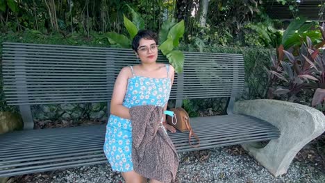 a beautiful malaysian indian lady sitting on a bench in the middle of a garden