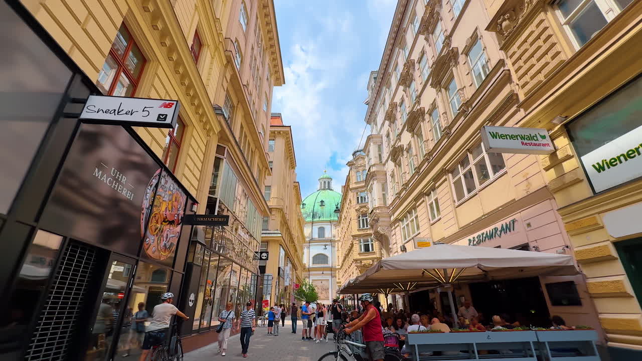 Vienna, Austria - June 9, 2025: Charming streets of Vienna. Tourists stroll through lively streets of Wien, surrounded by historic buildings and vibrant cafes under a clear sky