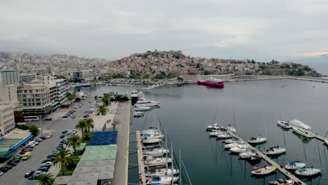 centro de la ciudad de kavala y puerto, toma aérea de dolly, vista de barcos de vela y panagia ciudad vieja en el fondo, macedonia oriental y tracia