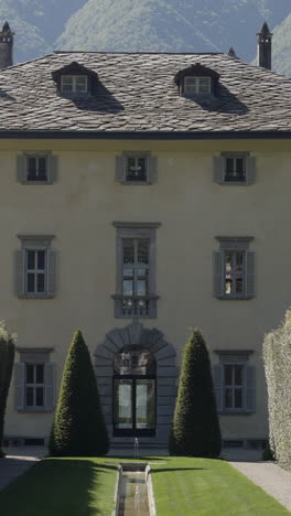 elegant historic villa with manicured gardens and mountain backdrop