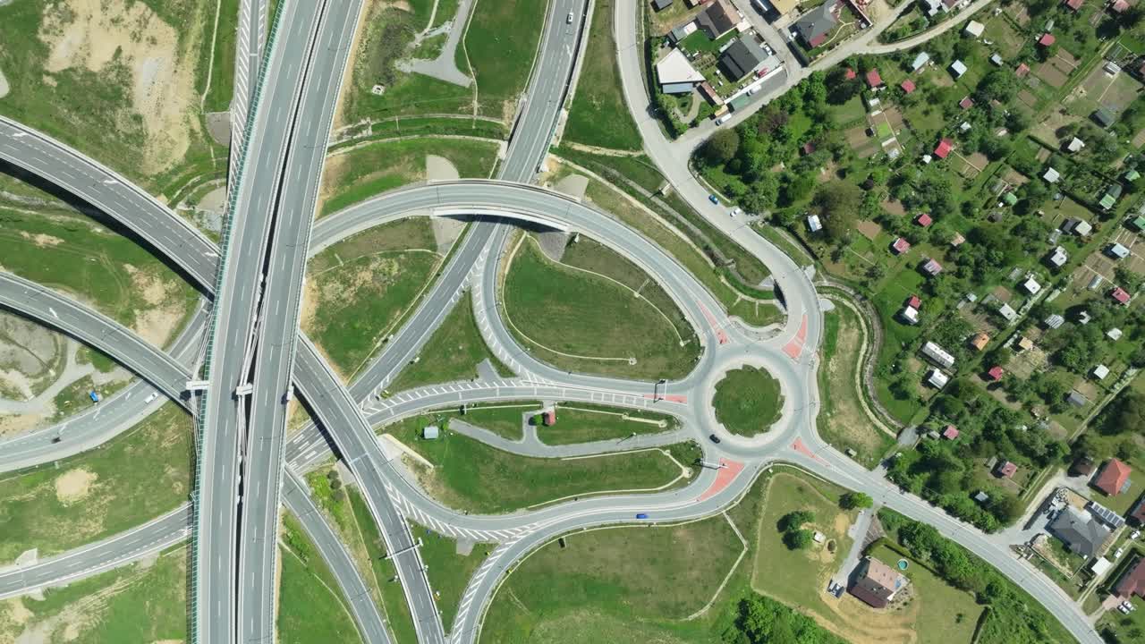 воздушный дрон с увеличенным прицелом захватывает сложный автомагистральный перекресток с автомобилями, движущимися по сложным кольцевым перекресткам и пересекающим дороги