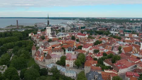 Eine-Drohnenaufnahme-Der-Estnischen-Altstadt-Von-Tallinn-Mit-Dem-Hafen-Im-Hintergrund-In-4k