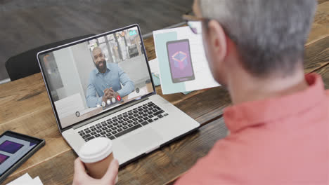 Hombre-De-Negocios-Caucásico-En-Videollamada-Portátil-Con-Un-Colega-Afroamericano-En-La-Pantalla