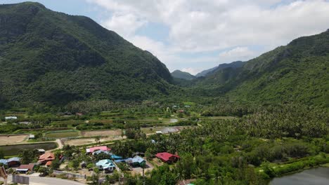 aerial footage sliding towards the right revealing a gorgeous mountain landscape and a village