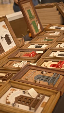 vertical shot of handcrafted wooden souvenirs and home decor from paraguay, displayed in a market for sale, featuring different colors and figures