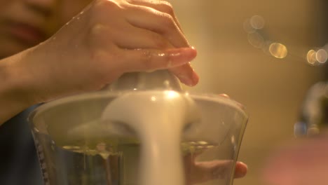 jugo de lima verde usando una máquina eléctrica de jugo de cítricos, filmado de cerca