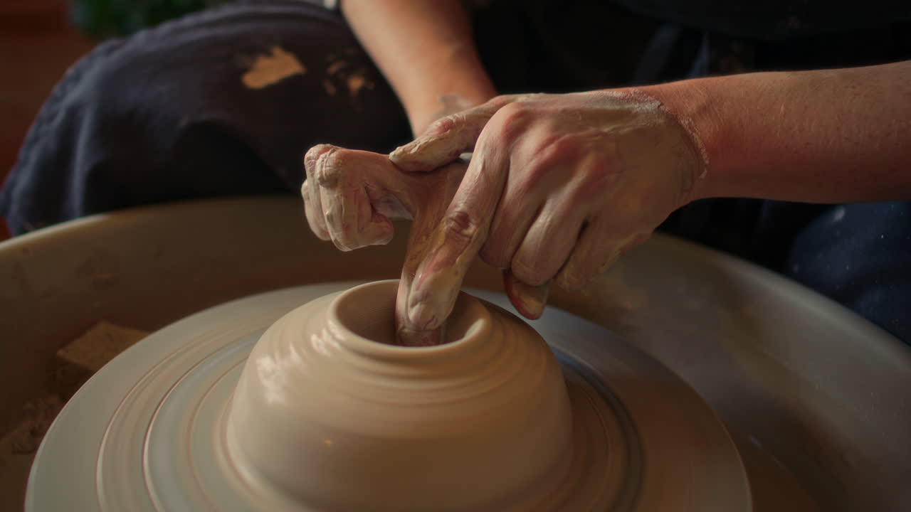 Close-Up of Hands of Artisan Forming Clay Vessel on Pottery Wheel