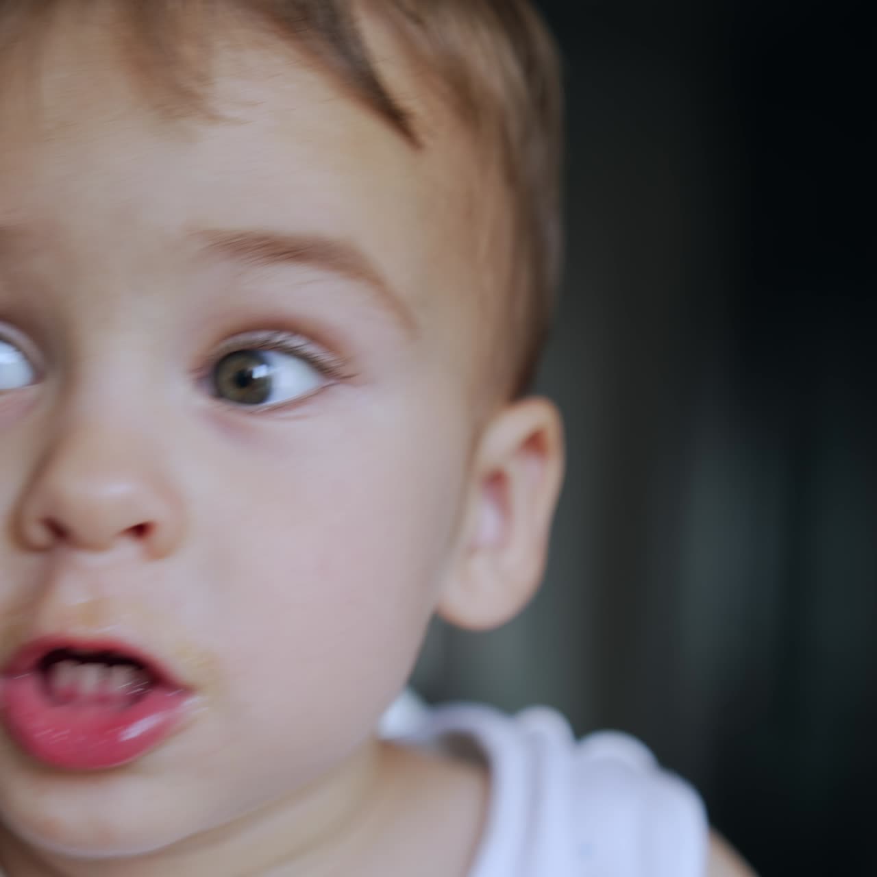 Caucasian baby boy refusing to eat. Adorable kid turns his head away from the given spoon. Close up