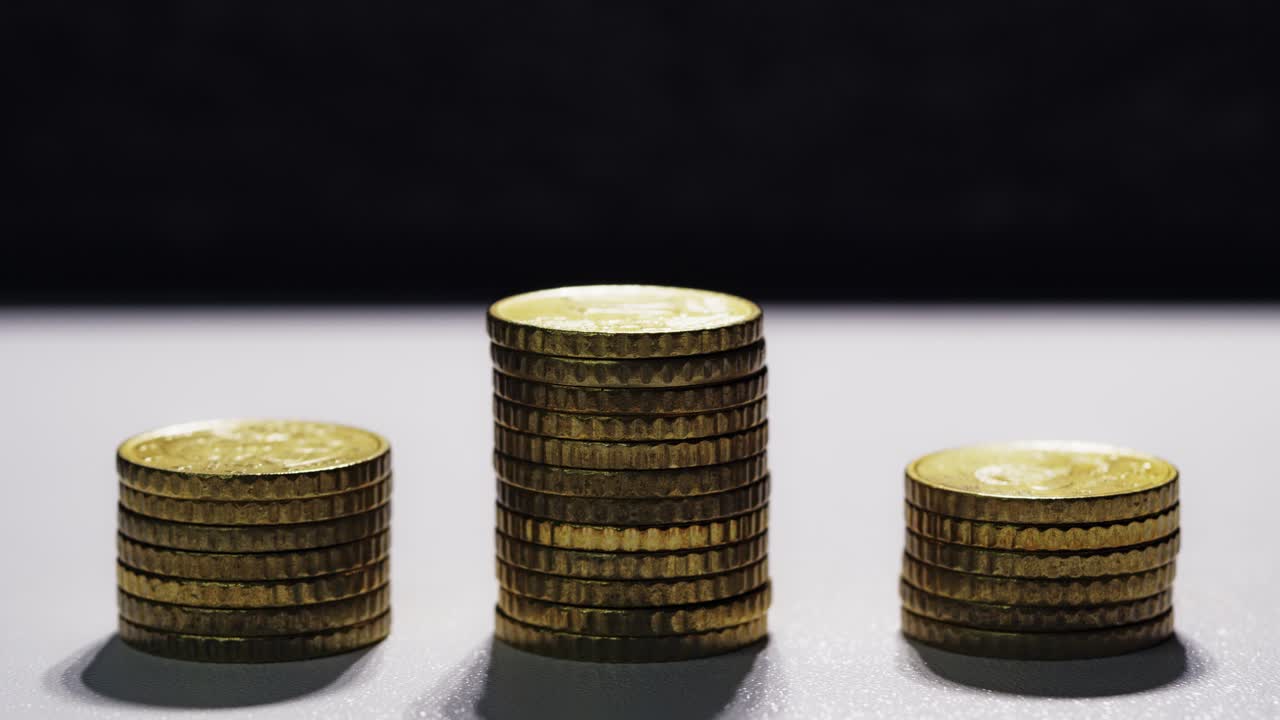Euro coin stacks rise and fall in a smooth loop, symbolizing economic cycles and financial volatility