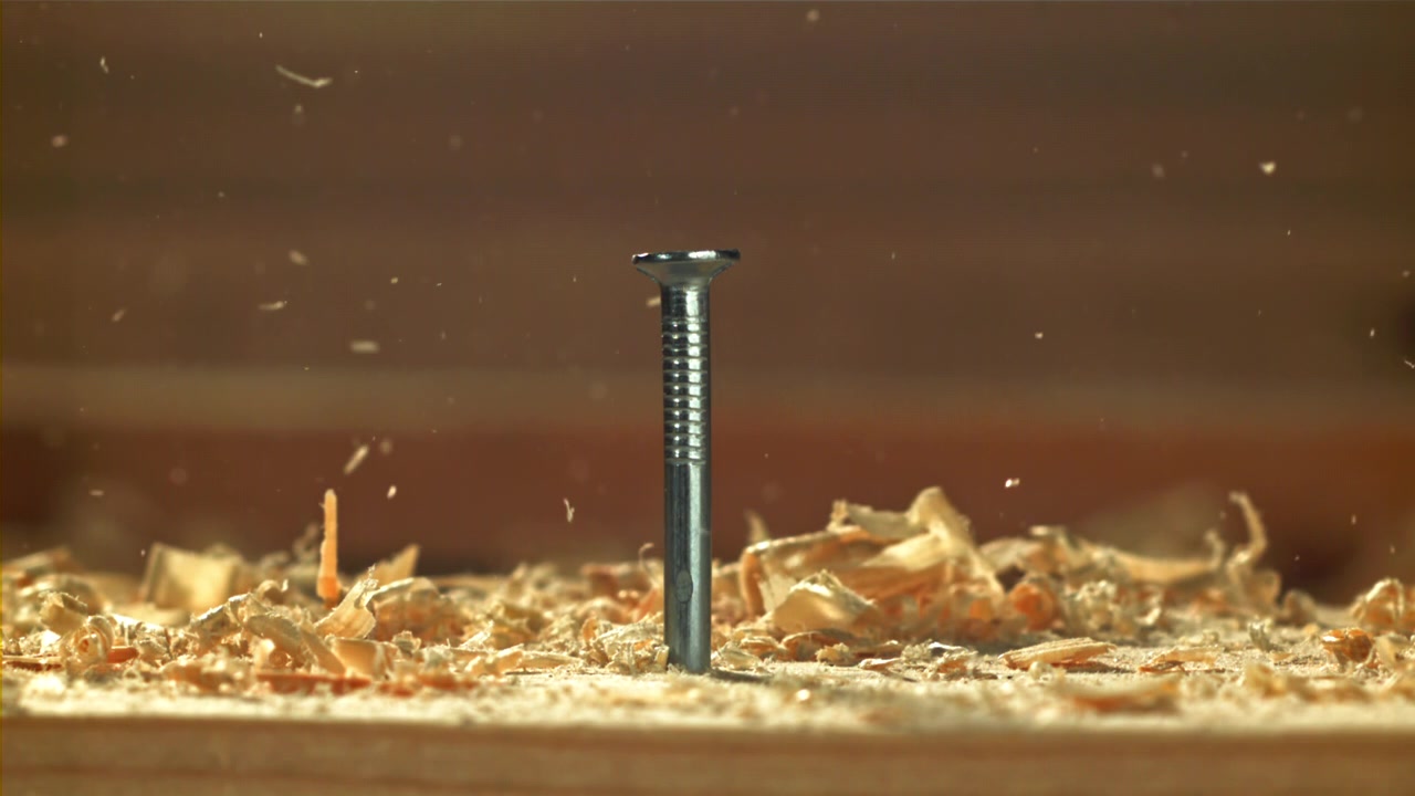 Close-up of a Metal Nail Hammered into Wood with Sawdust
