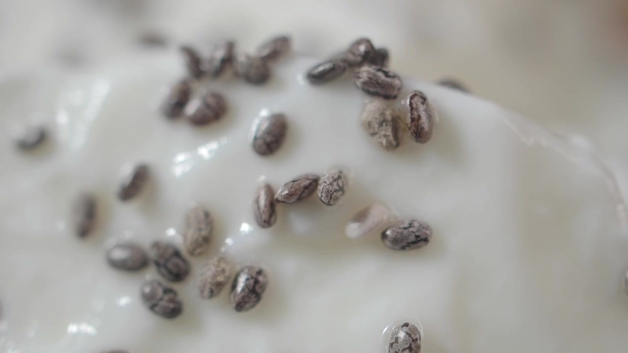 Primo piano di semi di chia cosparsi su yogurt cremoso.