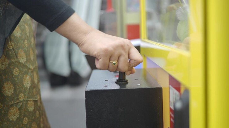 Person Playing Claw Crane Game at Arcade