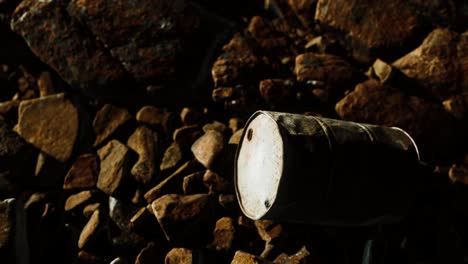 rusty destroyed metal barrel on beach rocks