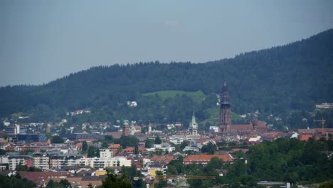 View-of-the-city-center-of-Freiburg,-Germany,-Black-Forest-in-the-background