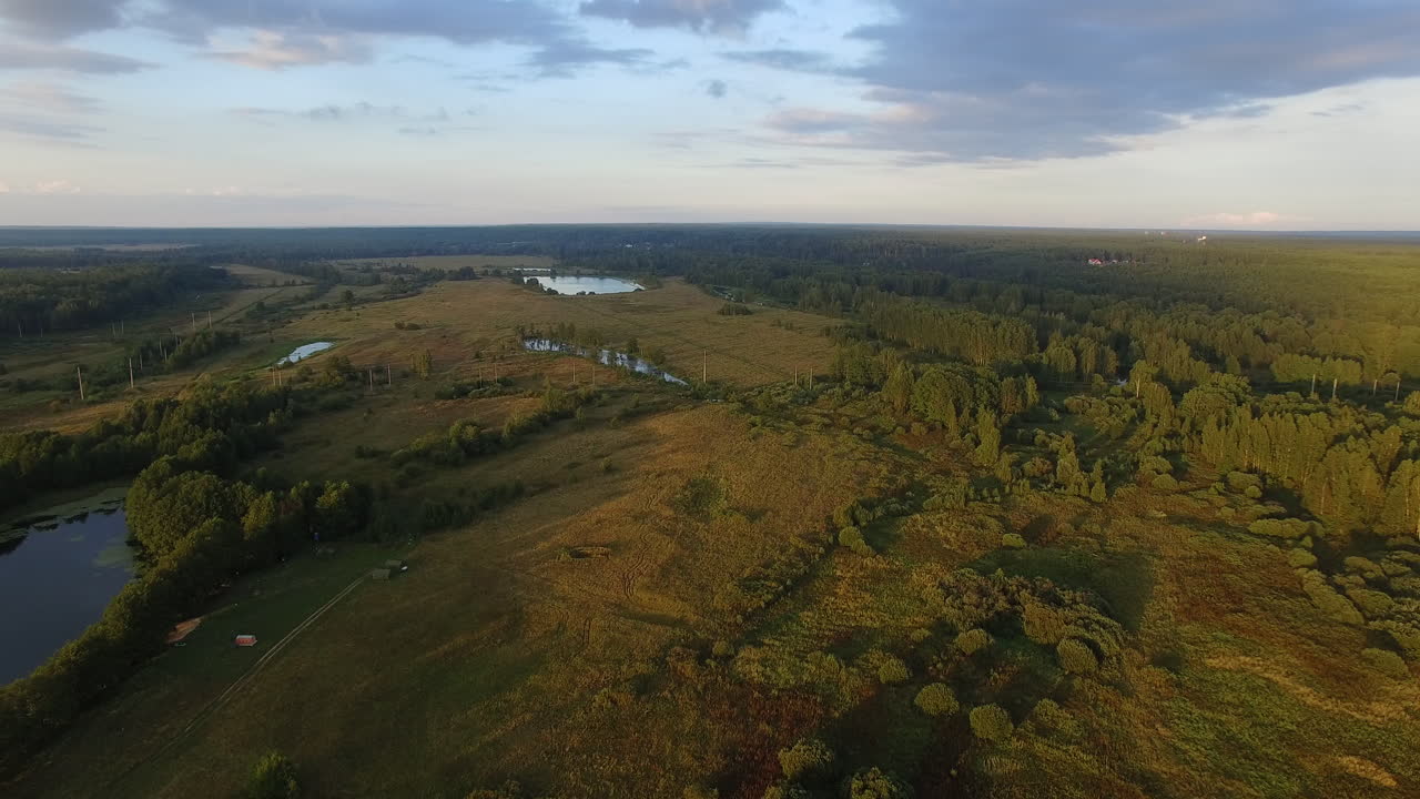 una vista aérea de un paisaje pintoresco con campos verdes y bosques contra el cielo azul
