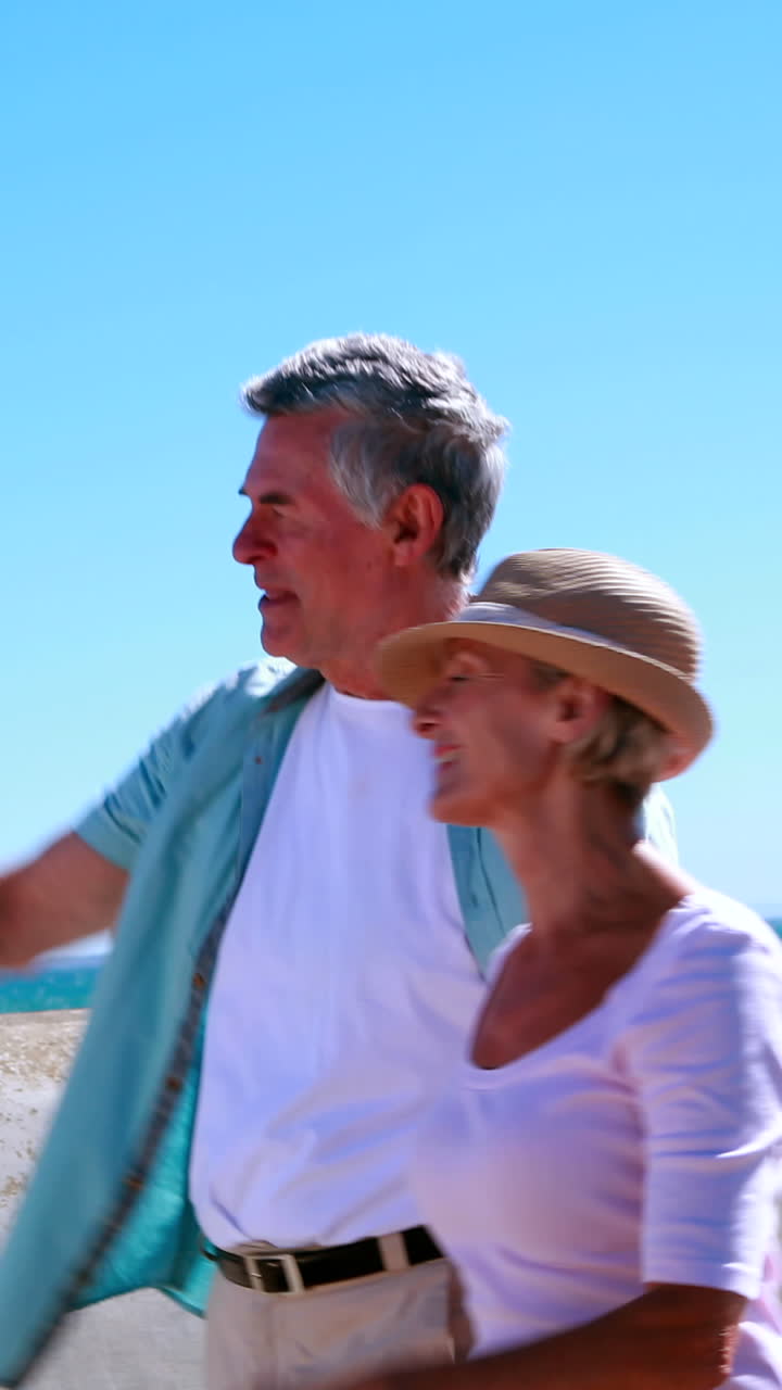 активные пожилые люди гуляют у моря