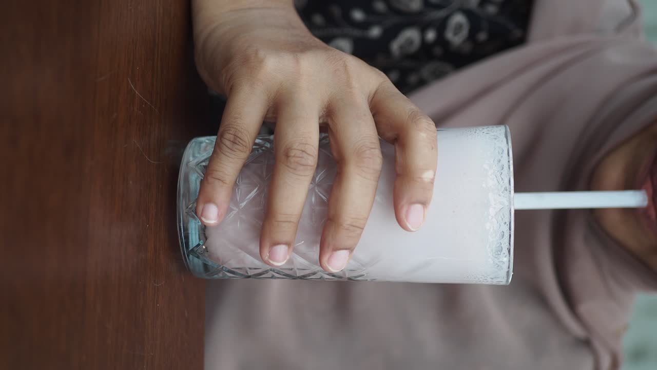 Persona che beve un frullato con una cannuccia