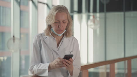 A-Blonde,-Middle-Aged-Female-Doctor-Sends-A-Mobile-Phone-Text-Message