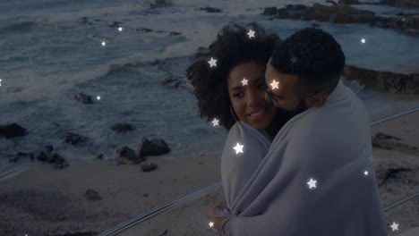 couple wrapped in blanket by ocean with stars animation