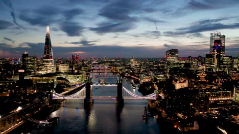 Aerial-View-of-London-over-the-River-Thames-including-Tower-Bridge,-Shard-and-the-Tower-of-London-at-twilight