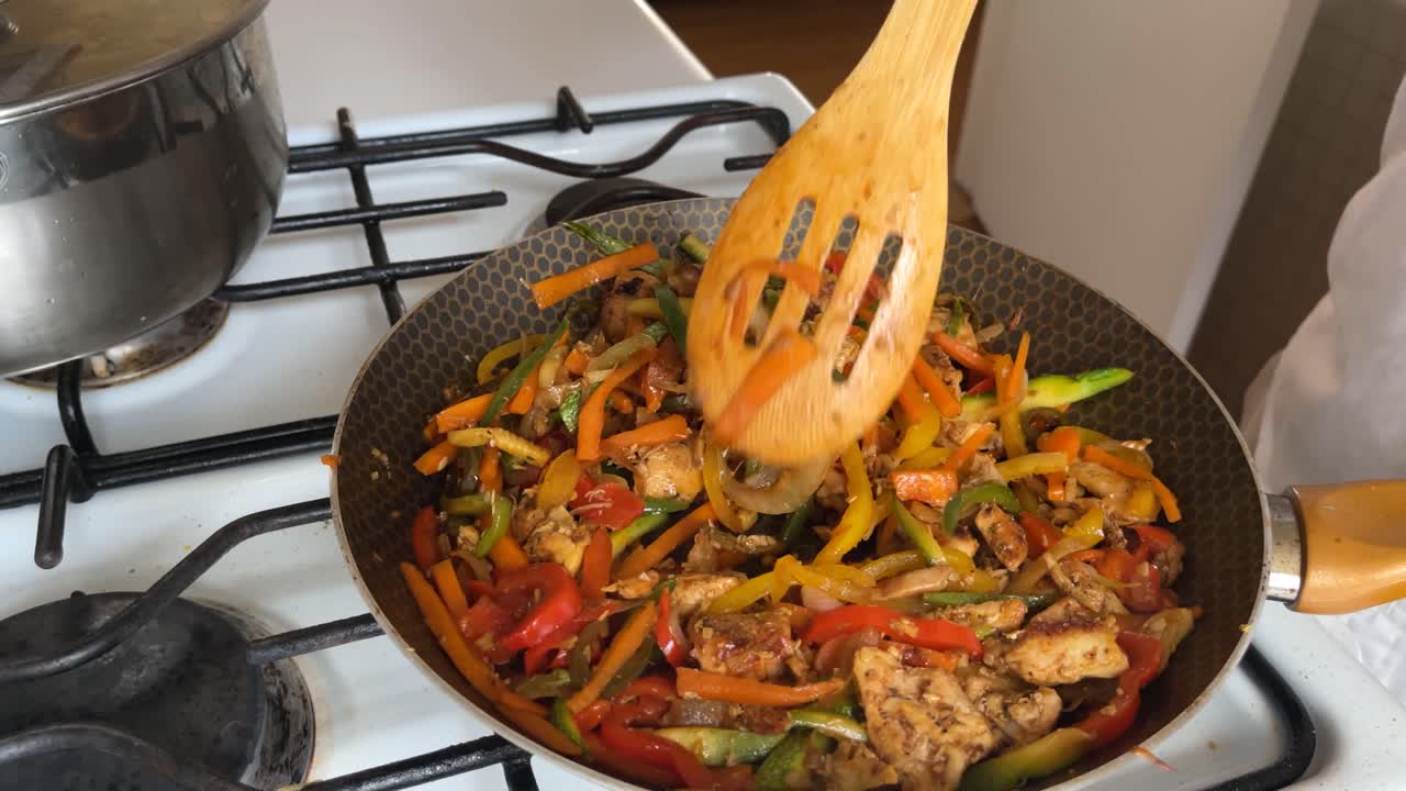 delicioso estofado de pollo con varias verduras julienned, cocinado a fuego lento en una sartén