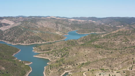 drone flight over a reservoir that occupies an entire valley between the mountains