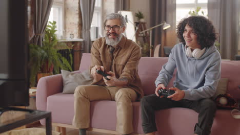 padre y hijo alegres jugando a un juego de consola juntos